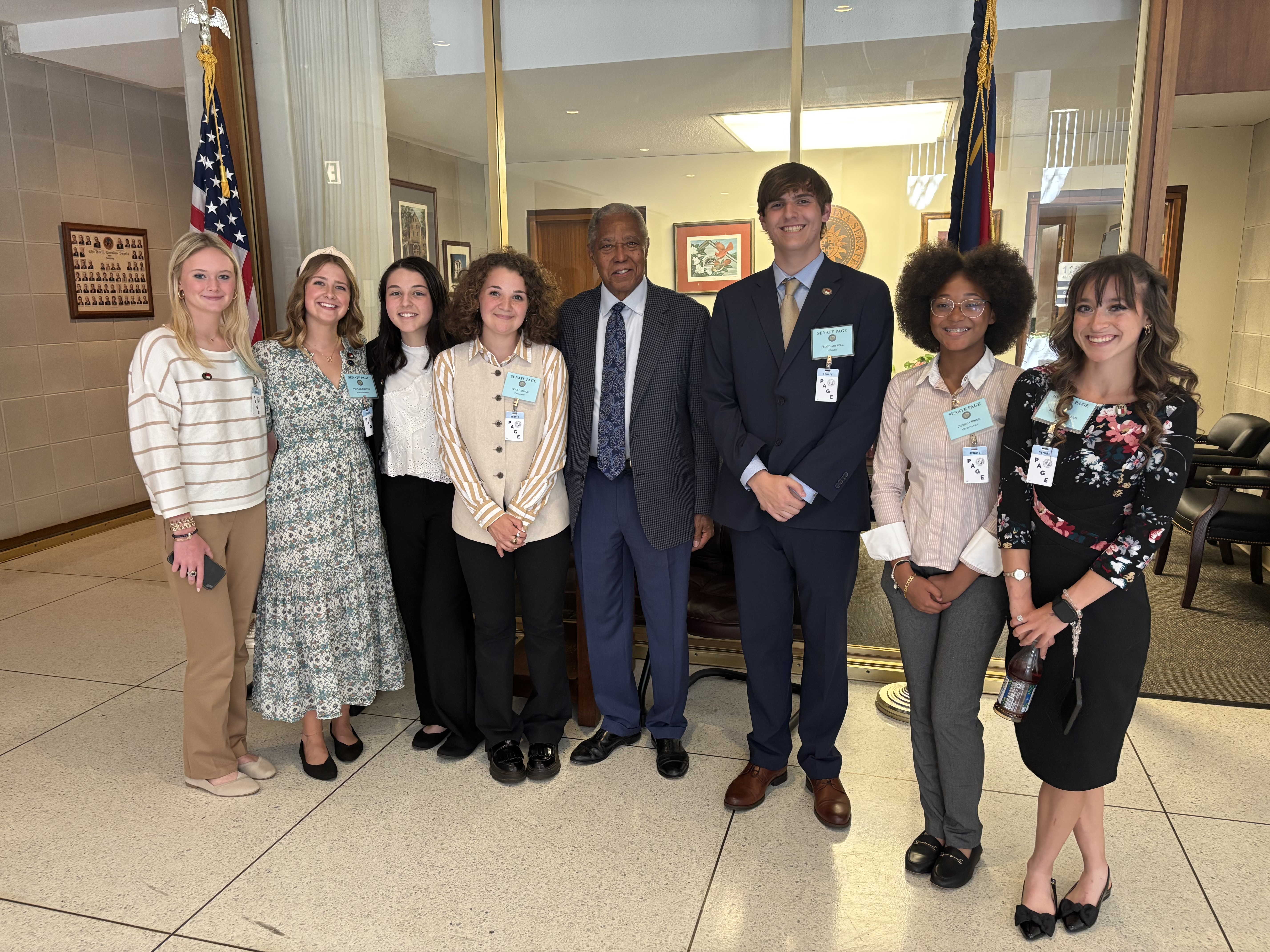 A group of pages posing for a picture with a Senator.